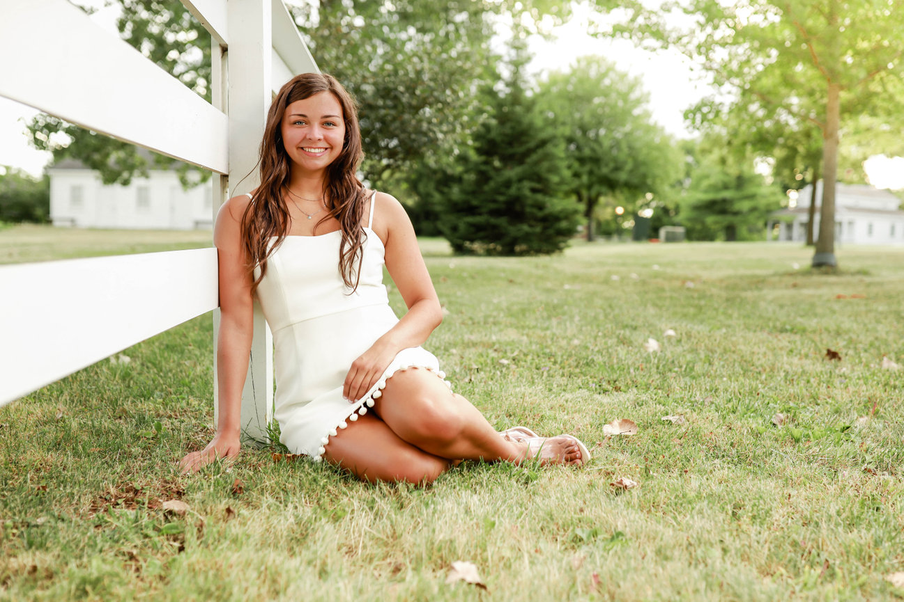 Teen girl smiling and posing during outdoor senior photo shoot in Farmington, MI