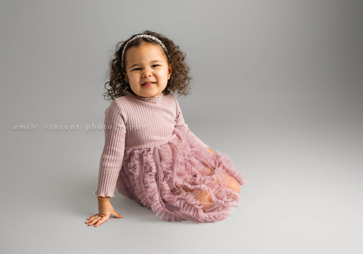 Child posing and smiling in cozy indoor portrait
