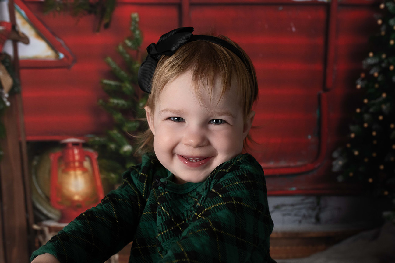 A little girl smiling in her Christmas dress