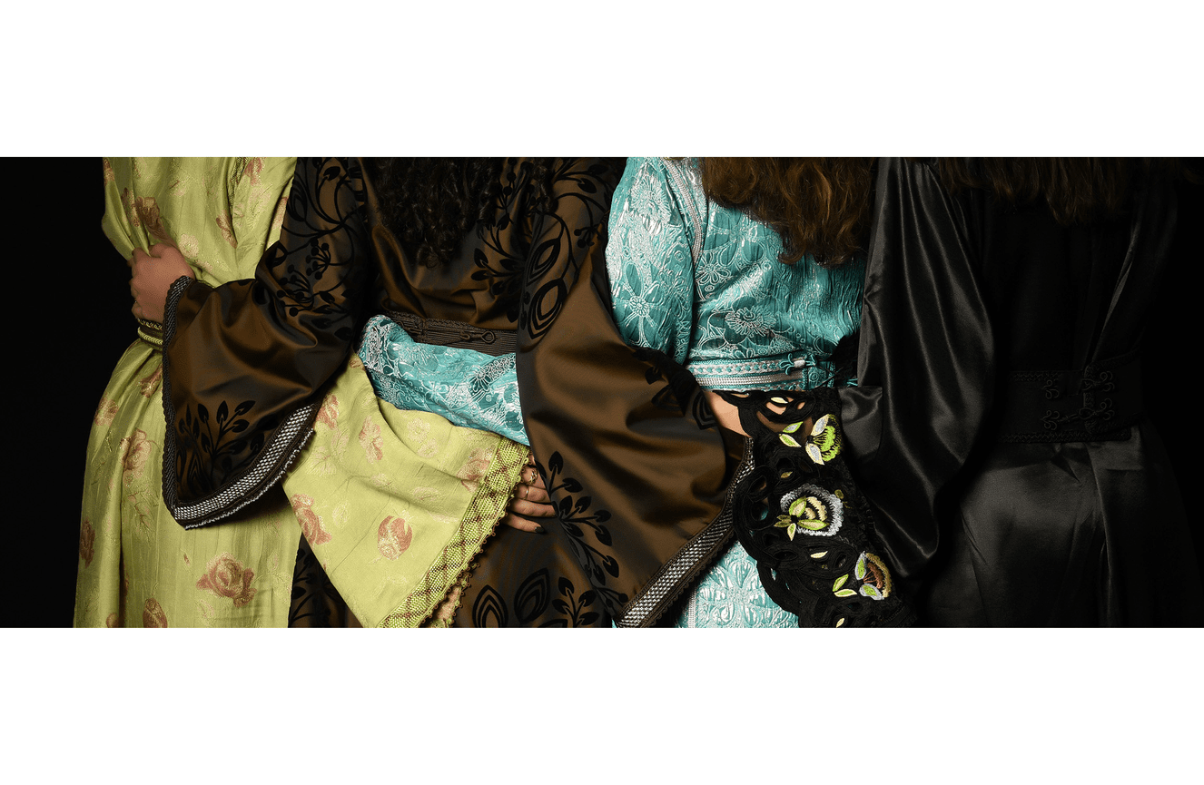 Four siblings with their arms wrapped around each other showing off their embellished native gowns.