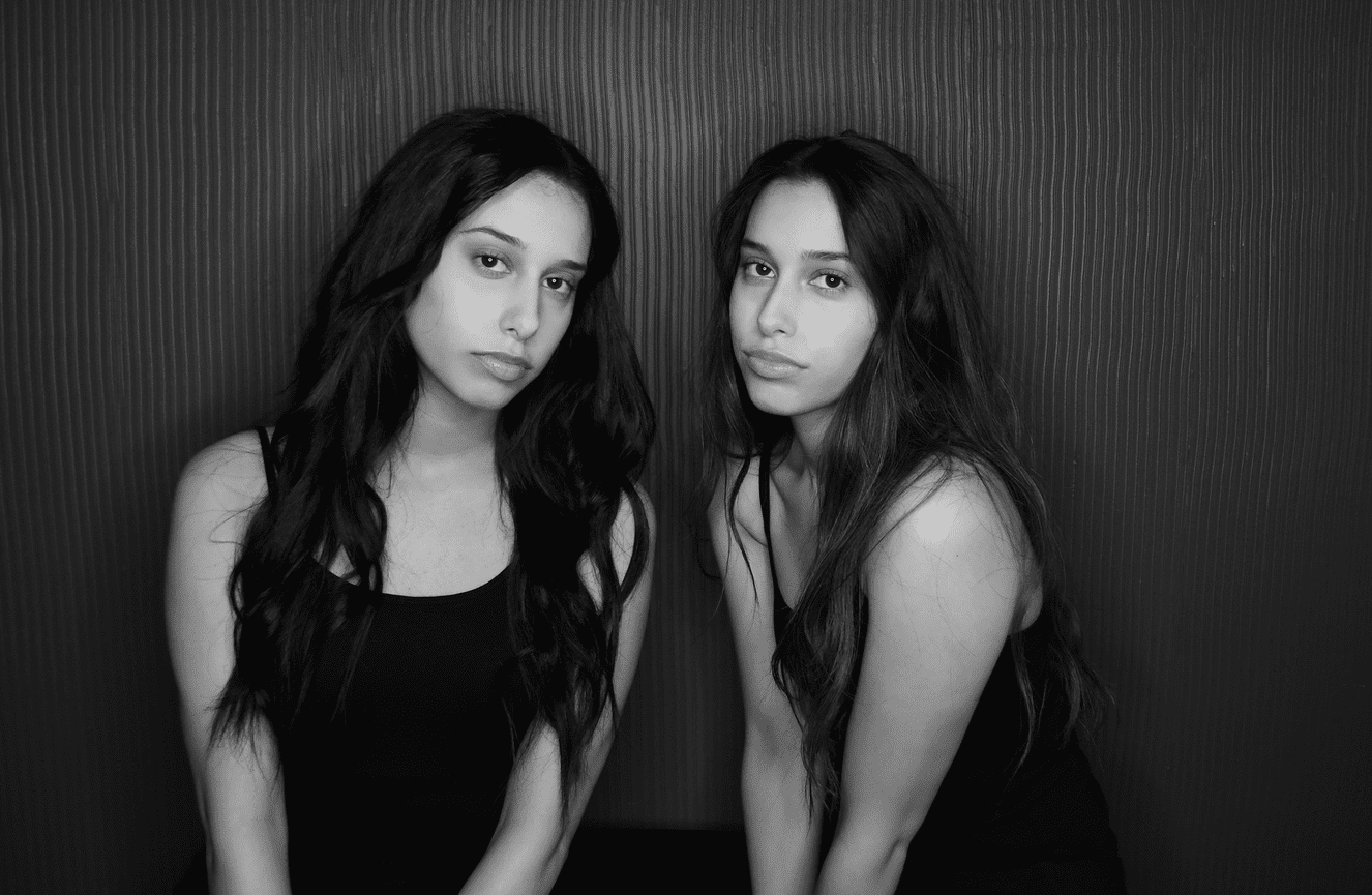 A black and white of twin teenage sisters during their senior photo session at Kliks Photography.