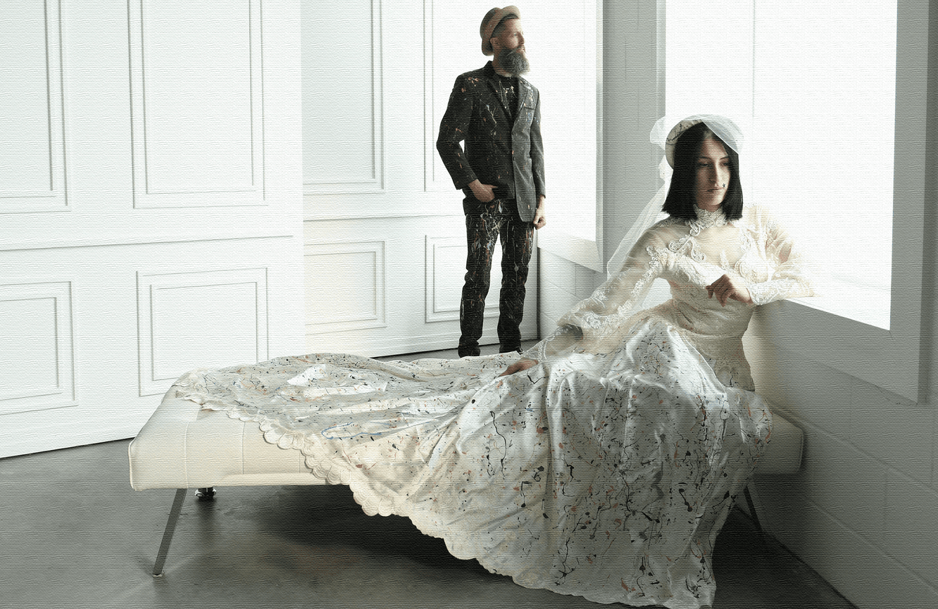 A creative photo of a bride and groom who pose looking out the window for an upcoming fashion show.