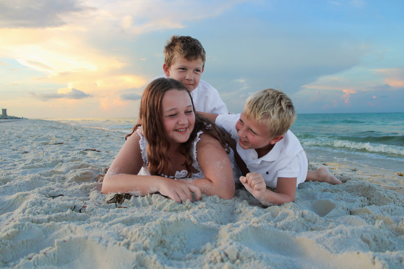 A family laughing together while lying on the beach