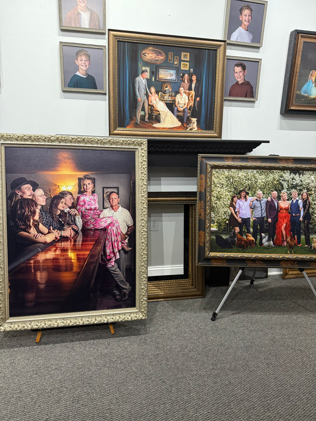 Framed portraits and artwork arranged around a fireplace in a home interior