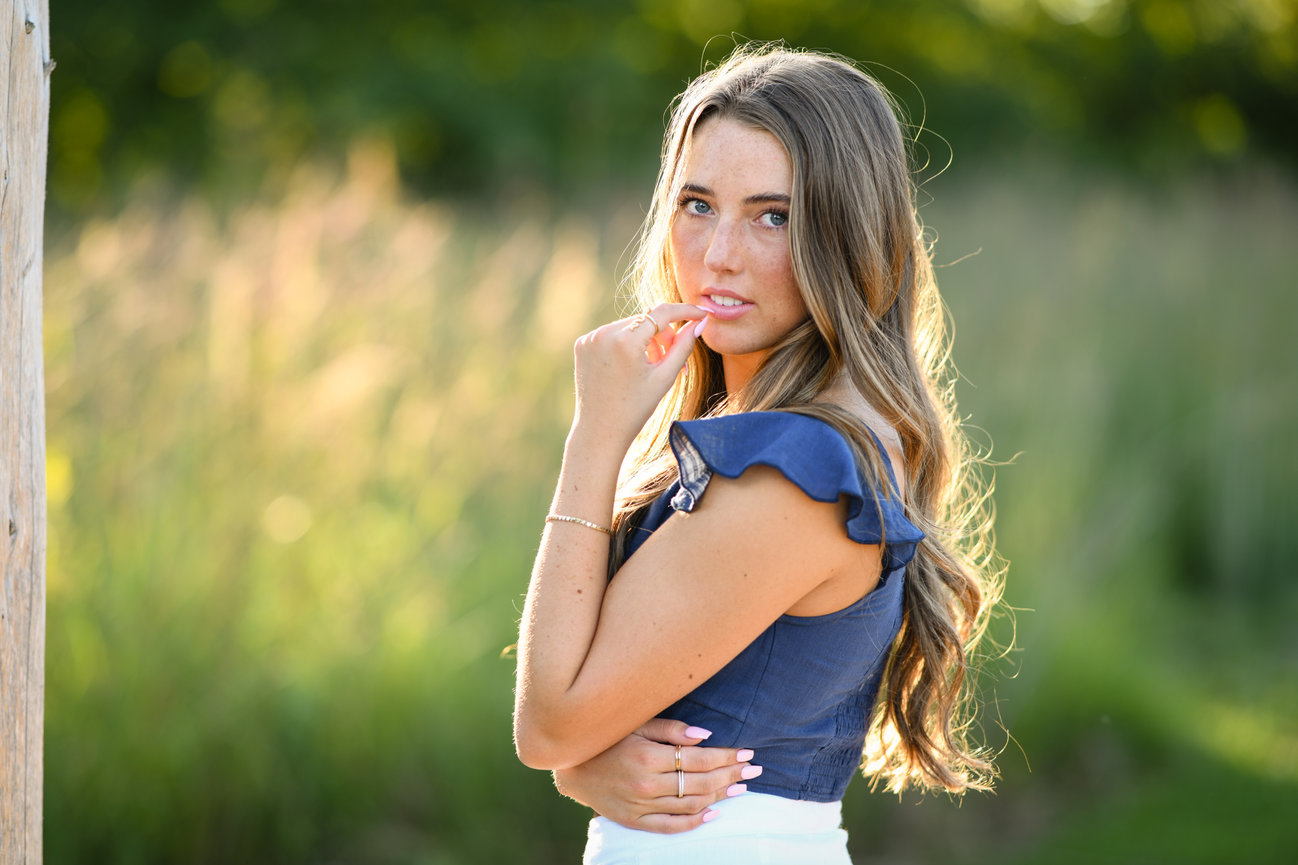 teenage senior girl standing in the golden hour sunlight for senior pictures in Dublin OH