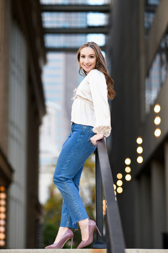 Teenage girl posing at the top of a staircase in an urban setting for senior photos in Dublin OH.