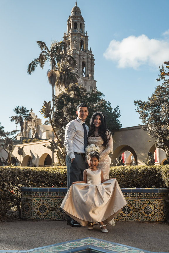 Family posing in historical park with tower backdrop