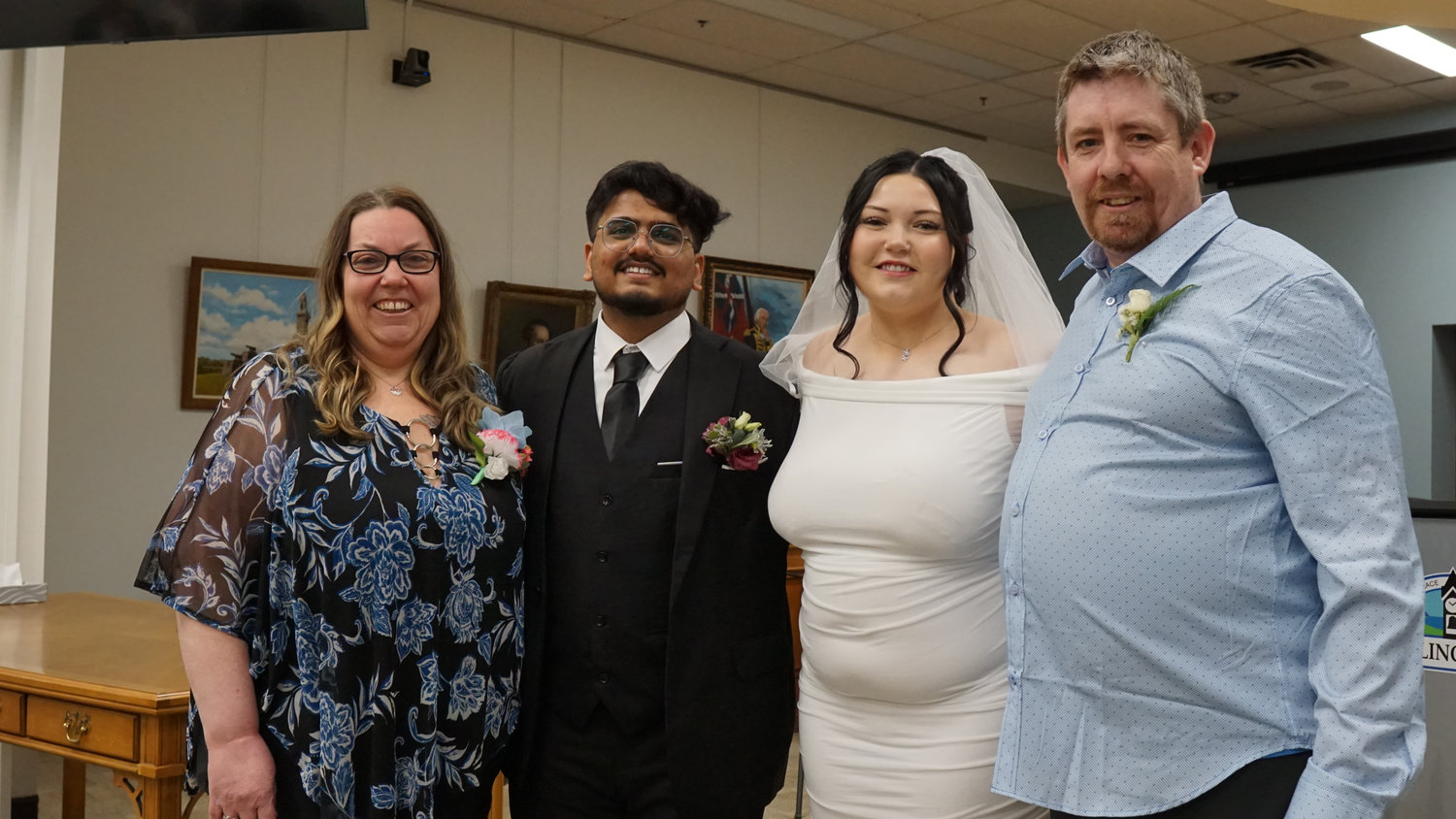 Wedding couple posing with family members in a ceremony room