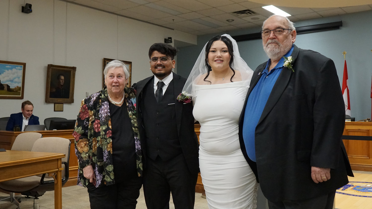 Wedding couple standing with relatives in a ceremony room